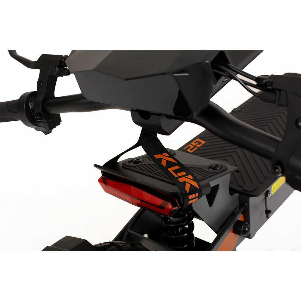 Close-up of the rear section of a KuKirin G2 800W black electric bike. It showcases powerful performance with a black seat, suspension spring, and red rear light. The frame features a strap with KUKA in orange and black graphics.