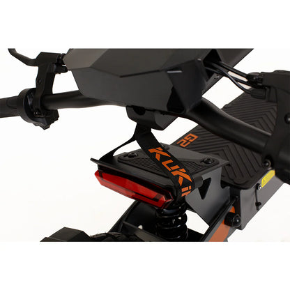 Close-up of the rear section of a KuKirin G2 800W black electric bike. It showcases powerful performance with a black seat, suspension spring, and red rear light. The frame features a strap with KUKA in orange and black graphics.